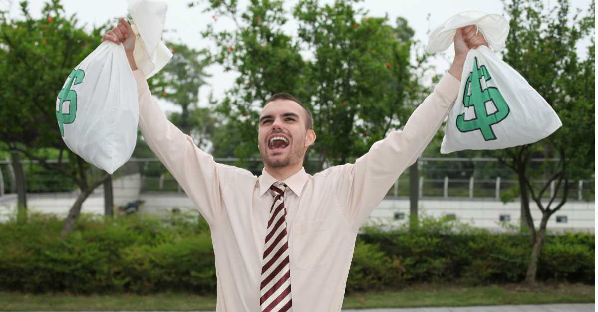 Is Being Debt-Free the New Rich? 1 Caucasian man wearing tie holding money bags over his head cheering