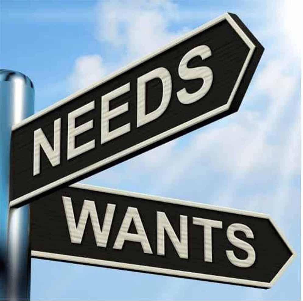 sign pointing in different directions for needs and wants