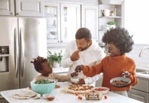 African American parents teach kids about money at dinner table while eating