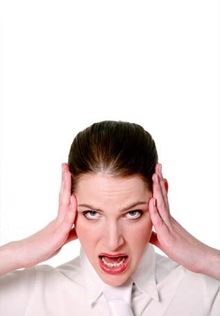 woman with brown hair holding her head in disgust