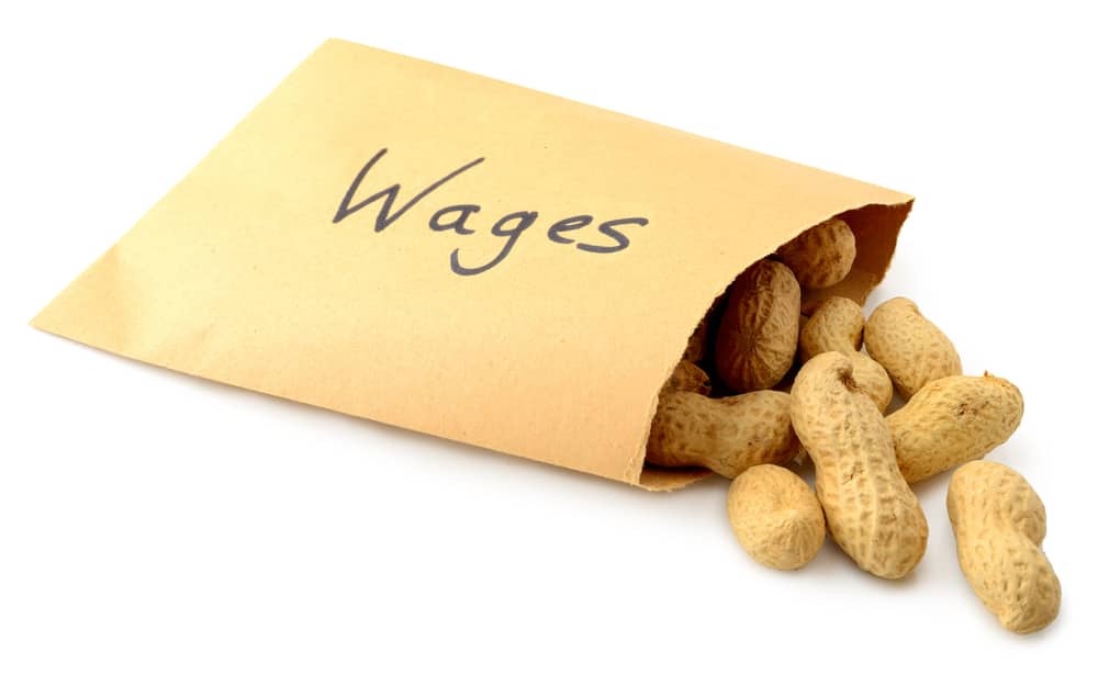 yellow envelope that says wages with peanuts falling out of it