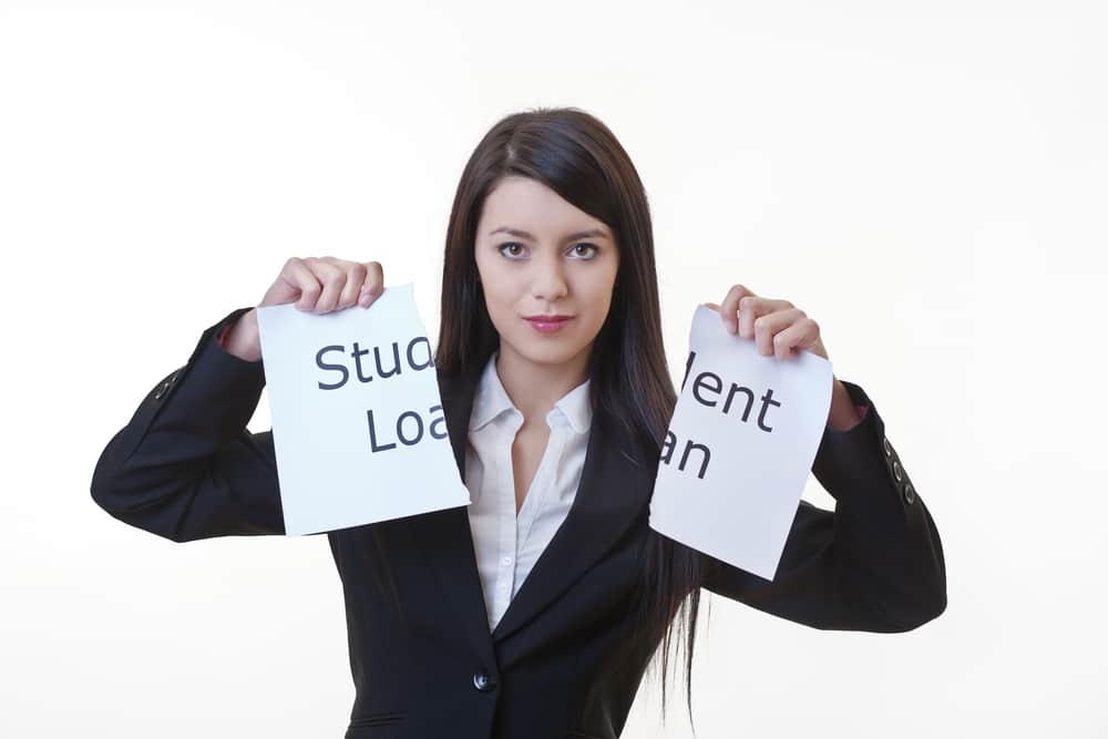 young caucasian woman in suit holding a ripped in half sign that says student loan