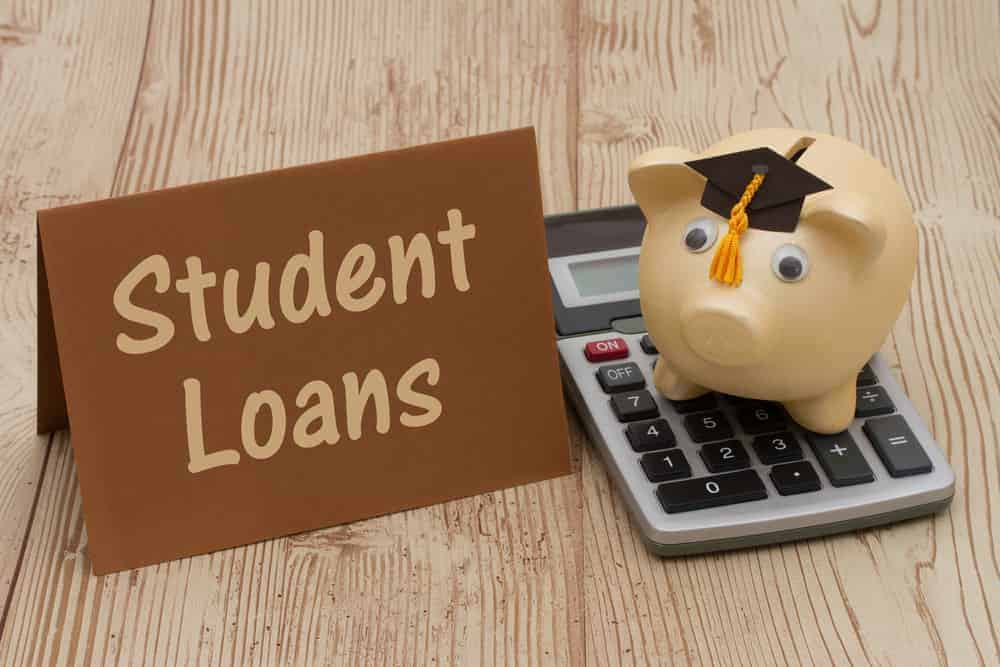 Brown student loan tag with a piggy bank on a calculator with a graduation hat