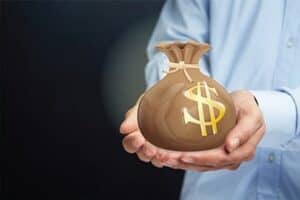 Person in blue shirt holding brown money back for how to save money in high school