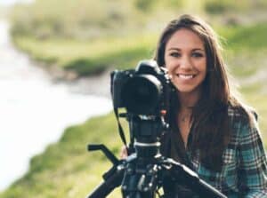 Teen girl with camera outdoors in nature for photography.