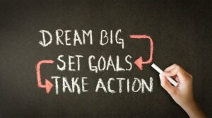 Writing stating dream big, set goals, take action with arrows from big to goals and set to take