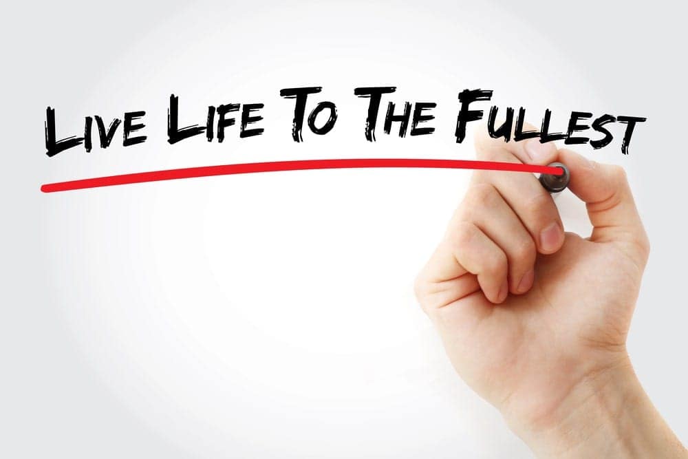 Hand writing 'Live Life To The Fullest' with a red marker.