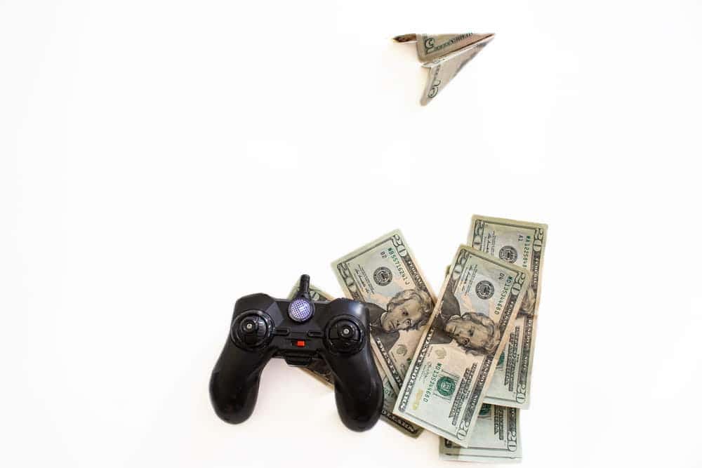 black joystick with u.s. dollars around it and one shaped into an airplane