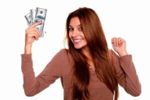 Teen girl holding cash, promoting saving money as a teenager without a job.