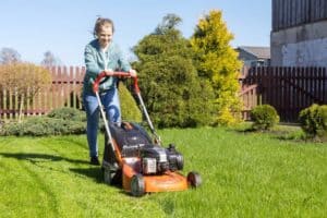 Teen mowing a lawn as part of a lawn care business
